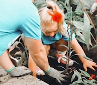 An adult and child are gardening together.